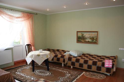 um quarto com uma cama, uma mesa e uma janela em Villa Ruben em Kamianets-Podilskyi