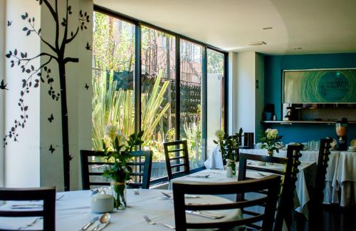 a dining room with tables and chairs and a large window at Apartaestudios Los Andes in Bogotá