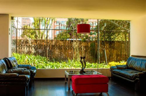 a living room with two couches and a large window at Apartaestudios Los Andes in Bogotá