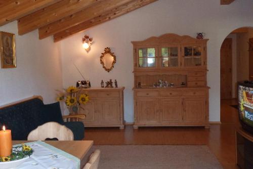 a living room with wooden cabinets and a table with a candle at Tratlhof in Achenkirch