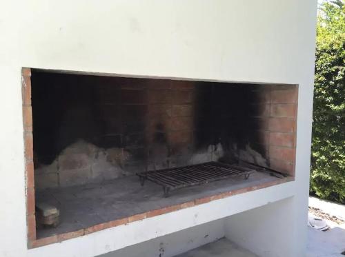 a brick fireplace with a grill inside of it at Casa en la Ruta del Malbec in Las Compuertas
