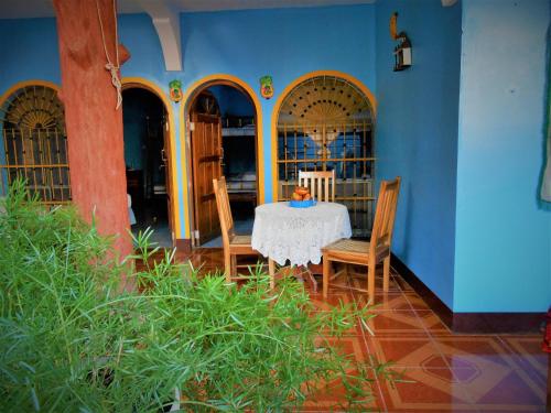 a table and chairs in a room with a blue wall at Hostal Siero in Moyogalpa