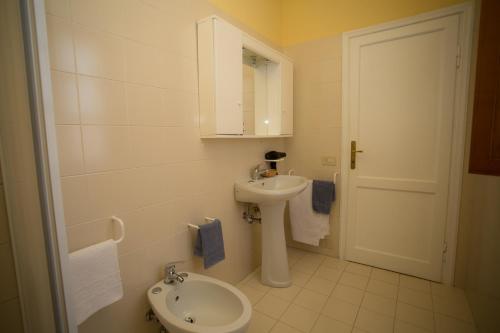 Un baño blanco con lavabo e inodoro. en Guido's House, en Castiglion Fiorentino
