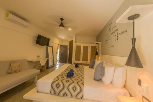 a bedroom with a large white bed and a couch at Hotel Luna De Plata in Mahahual