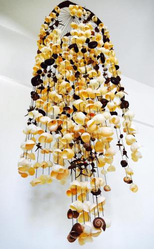 a chandelier made out of shells on a wall at Hotel Luna De Plata in Mahahual