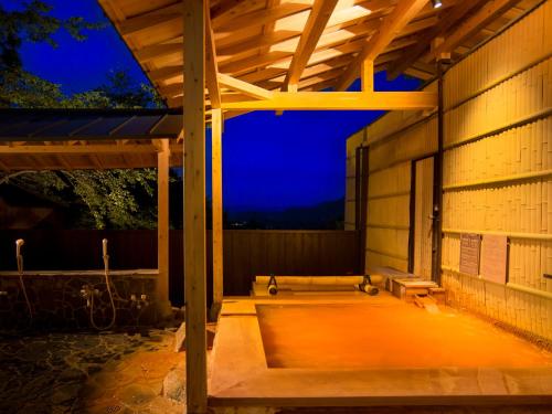 a pavilion with a bench on a patio at night at Arima Onsen Motoyu Ryuusenkaku in Kobe