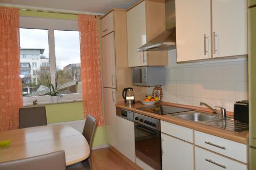 a small kitchen with a table and a sink and a window at BS Business Travelling Hannover City in Hannover