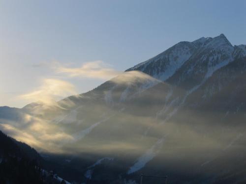 a mountain obscured by a layer of fog in front of a mountain at Landhaus Steiner in Schladming