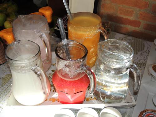 a tray with three glass containers of drinks on a table at Pousada Cantinho das Estrelas in Monte Verde