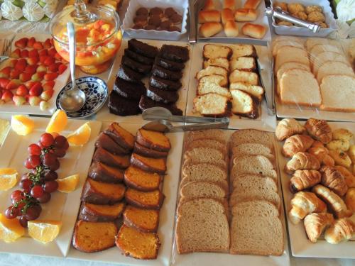 a buffet of different types of food on a table at Pousada Cantinho das Estrelas in Monte Verde