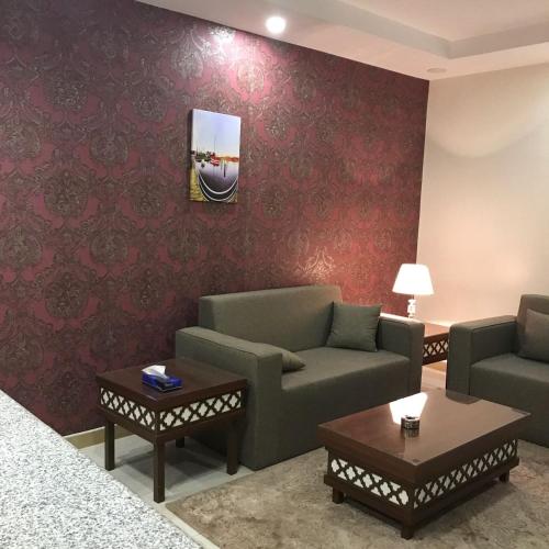 a living room with two couches and a table at تاج الخليج للشقق المخدومة in Dammam