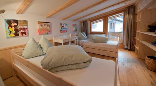 a bedroom with two beds and a window at Chasa Seraina in Samnaun