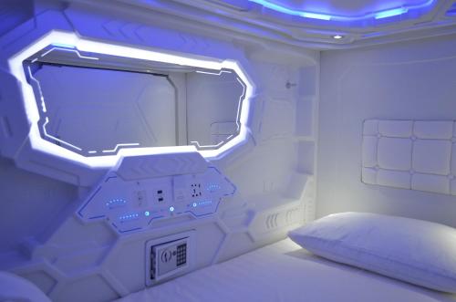 a room with a bed with a tv and a bed sidx sidx sidx at Capsule hotel Zodiac in Vladivostok