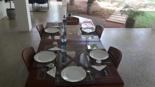 a wooden table with chairs and plates on it at Sudunelum Holiday Resort in Anuradhapura