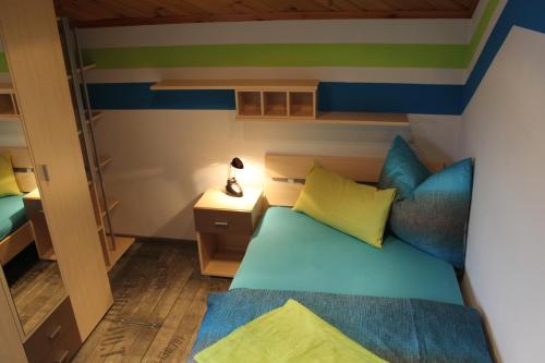 マリアプファルにあるNeumann Ferienwohnung Fanningのベッド1台、ナイトスタンドのランプが備わる小さな客室です。