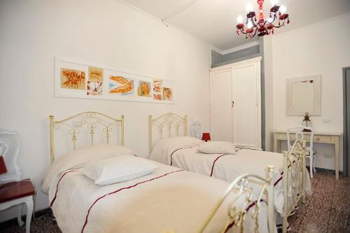 una camera con due letti e un lampadario a braccio di La Fontana di Nonna Checchina a Villa San Giovanni in Tuscia