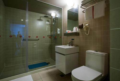 La salle de bains est pourvue d'une douche, de toilettes et d'un lavabo. dans l'établissement Jinjiang Inn Select Shaoxing Jiefang North Road, à Shaoxing