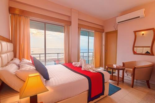 a bedroom with a bed with a view of the ocean at Hotel Sea Crown in Cox's Bazar