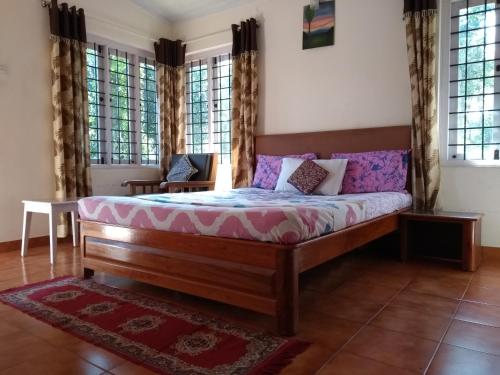 ein Schlafzimmer mit einem Bett in einem Zimmer mit Fenstern in der Unterkunft Coorg 4 C's Little Paradise in Madikeri