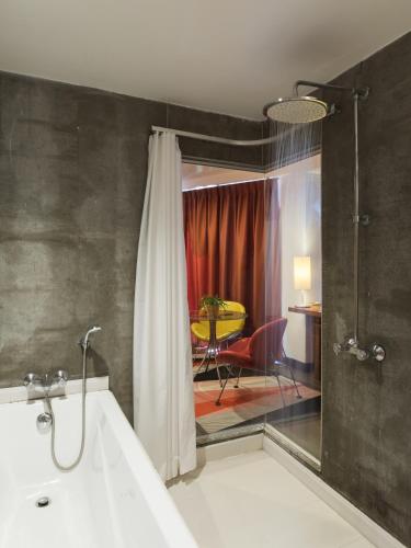 a bathroom with a shower and a sink and a room at Sandalay Resort in Pattaya