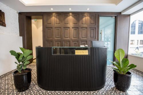 a lobby with two potted plants in front of a door at The Southern Boutique Hotel in George Town