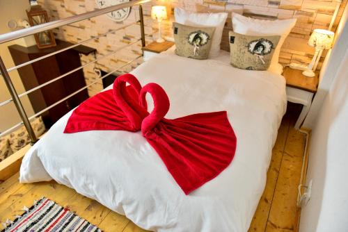 a red bow on a bed in a room at Duplex Alexander in Braşov