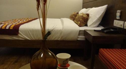 a bedroom with a bed with a vase on a table at Utse Suites in Bengaluru