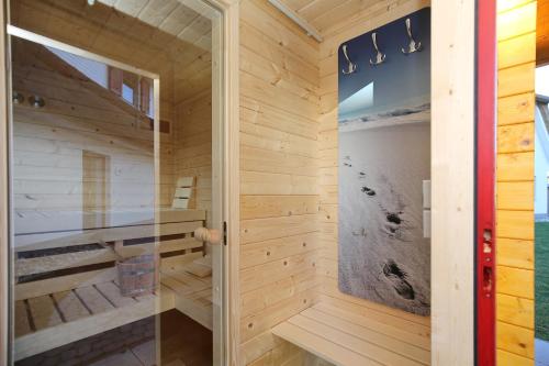 a sauna with wooden walls and a glass door at Dat Smucke Huus - 6 Personen strandnah unter Reet in Boltenhagen - 3 SZ - Finnische Sauna - 2 Strandkörbe - Strand 650m in Boltenhagen