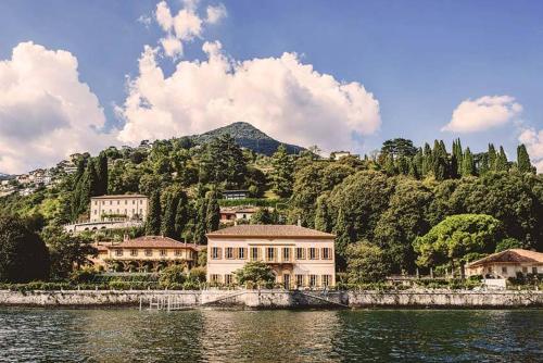 チェルノッビオにあるElegant Sweet Apt Cernobbio Centroの水域の隣の丘の上にある大きな建物