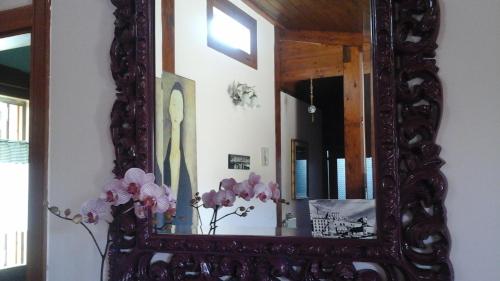 a mirror with a vase of flowers in a room at 'O Chalet in Pozzuoli