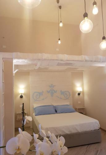 una camera da letto con letto con cuscini blu e fiori bianchi di Recondita Armonia a Sorrento