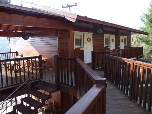a cabin with a deck with a table and chairs at Ktima Noosfera Wellness & Retreat Center in Nees Vrisoules