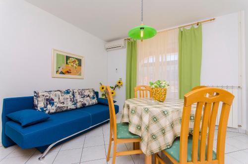 a living room with a blue couch and a table at Apartments Biserka in Novalja