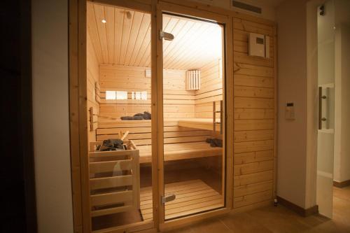 una sauna con pareti in legno e una porta in vetro di Weinberghaus Prossen a Bad Schandau