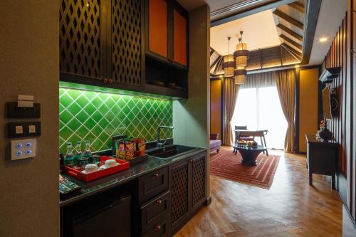 a kitchen with green tile on the wall at Chala Number6 in Chiang Mai