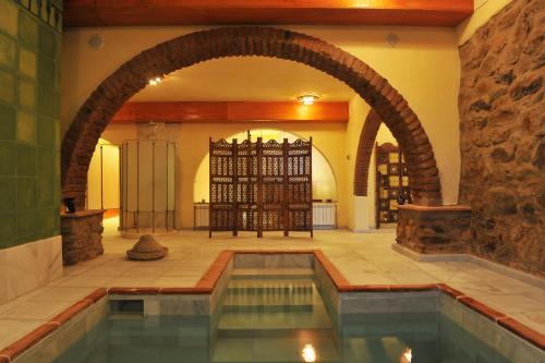 una piscina cubierta con un arco en un edificio en La Molinilla Apartamentos y Hammam en Linares de la Sierra