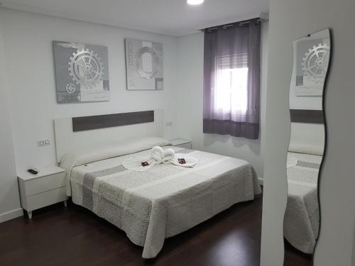 a hotel room with a bed, desk, and television at Hostal Goyesco Plaza in Plasencia