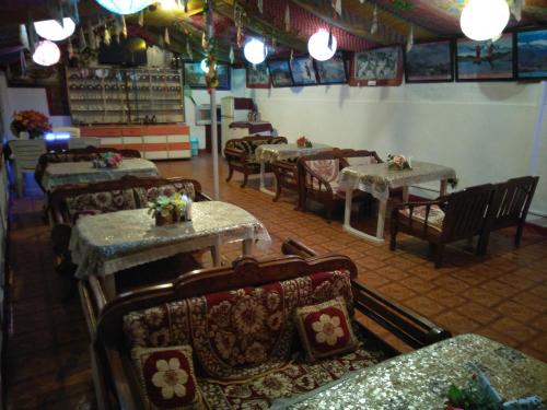 a restaurant with tables and chairs in a room at Hotel Victoriya Palace,Mcleod Ganj in McLeod Ganj