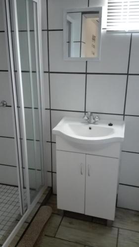 a white bathroom with a sink and a mirror at Dreams in Beaufort West