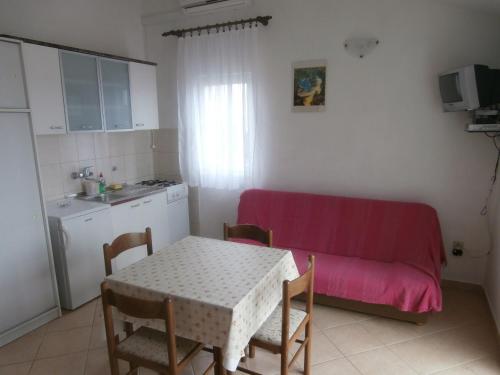 salon ze stołem i czerwoną kanapą w obiekcie Apartments Nada w mieście Vodice