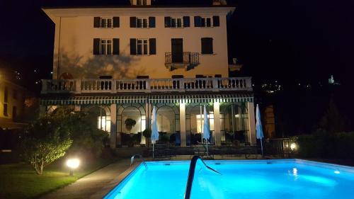 un edificio con piscina frente a un edificio en Hotel La Villa, en Gravedona