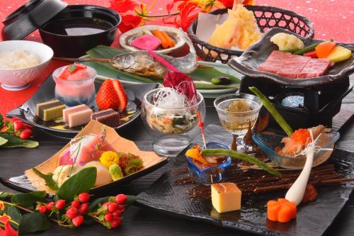 uma mesa com diferentes tipos de alimentos e bebidas em Okunikko Konishi Hotel em Nikko
