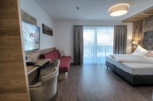 a hotel room with a bed and a couch at Hotel Eldorado in Ischgl