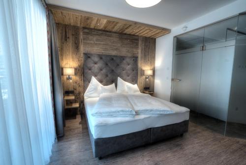 a bedroom with a large bed with a large headboard at Hotel Eldorado in Ischgl