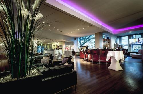 a restaurant with tables and chairs and purple lighting at Schlosshotel Kassel in Kassel