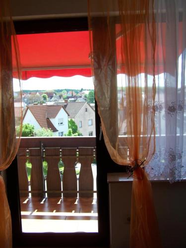 a view of a balcony from a window with curtains at Bea's Monteurzimmer in Seckach