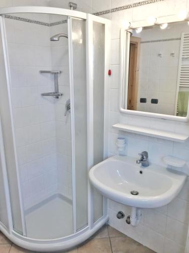 a white bathroom with a shower and a sink at Bait Ables in Livigno