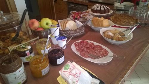 ein Tisch mit vielen verschiedenen Arten von Lebensmitteln in der Unterkunft Agriturismo Mazzeracca in Bassano del Grappa