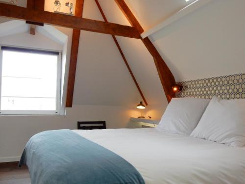 a bedroom with a white bed and a window at Boutique B&B Nassau in Amsterdam