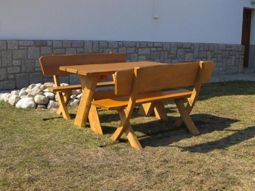a wooden picnic table and bench in the grass at Berger Pec Privat in Pec pod Sněžkou